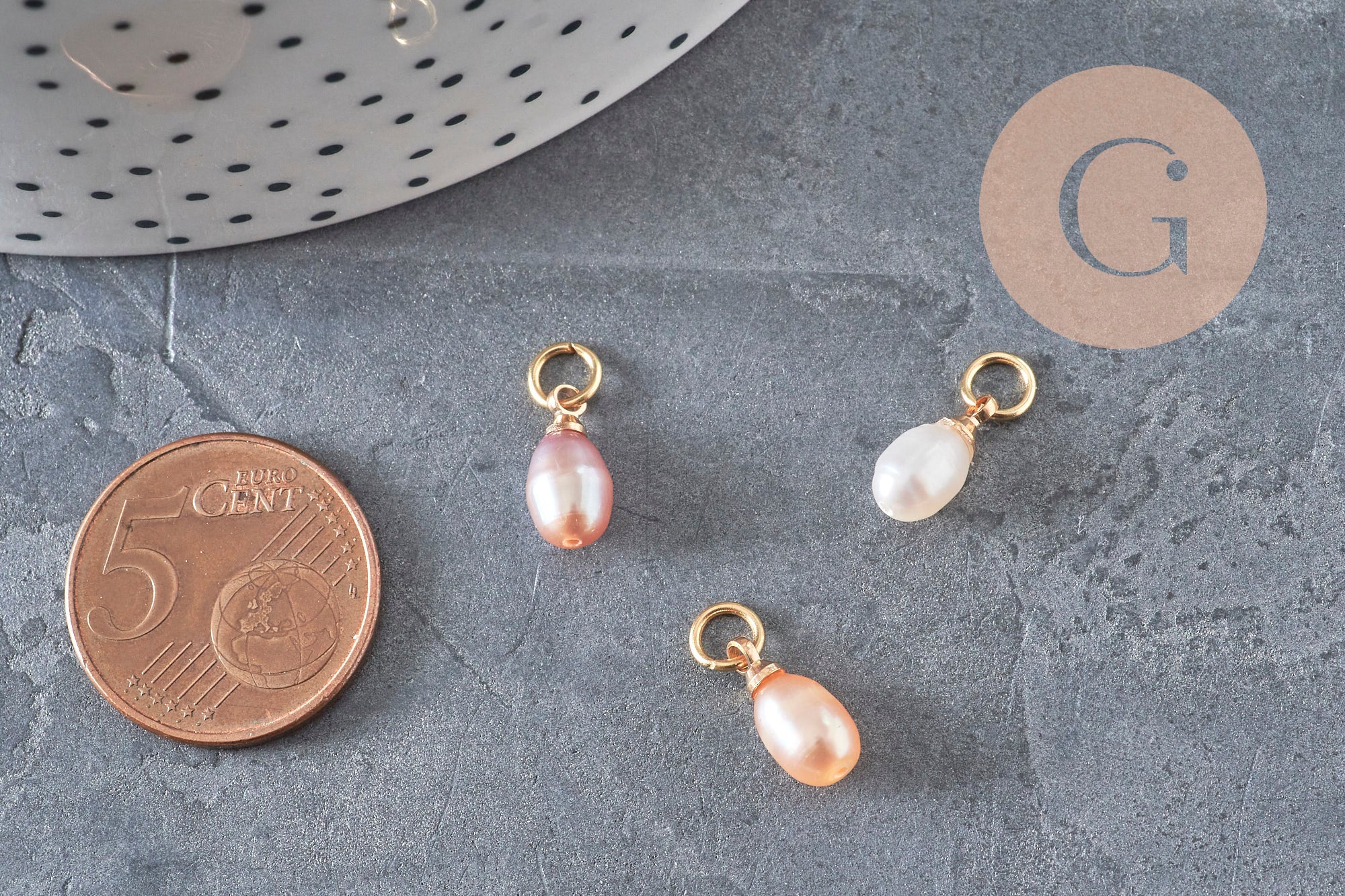 Trois breloques en perle d'eau douce naturelle forme goutte, teintes rose pêche et blanc, montées sur anneau en laiton doré.