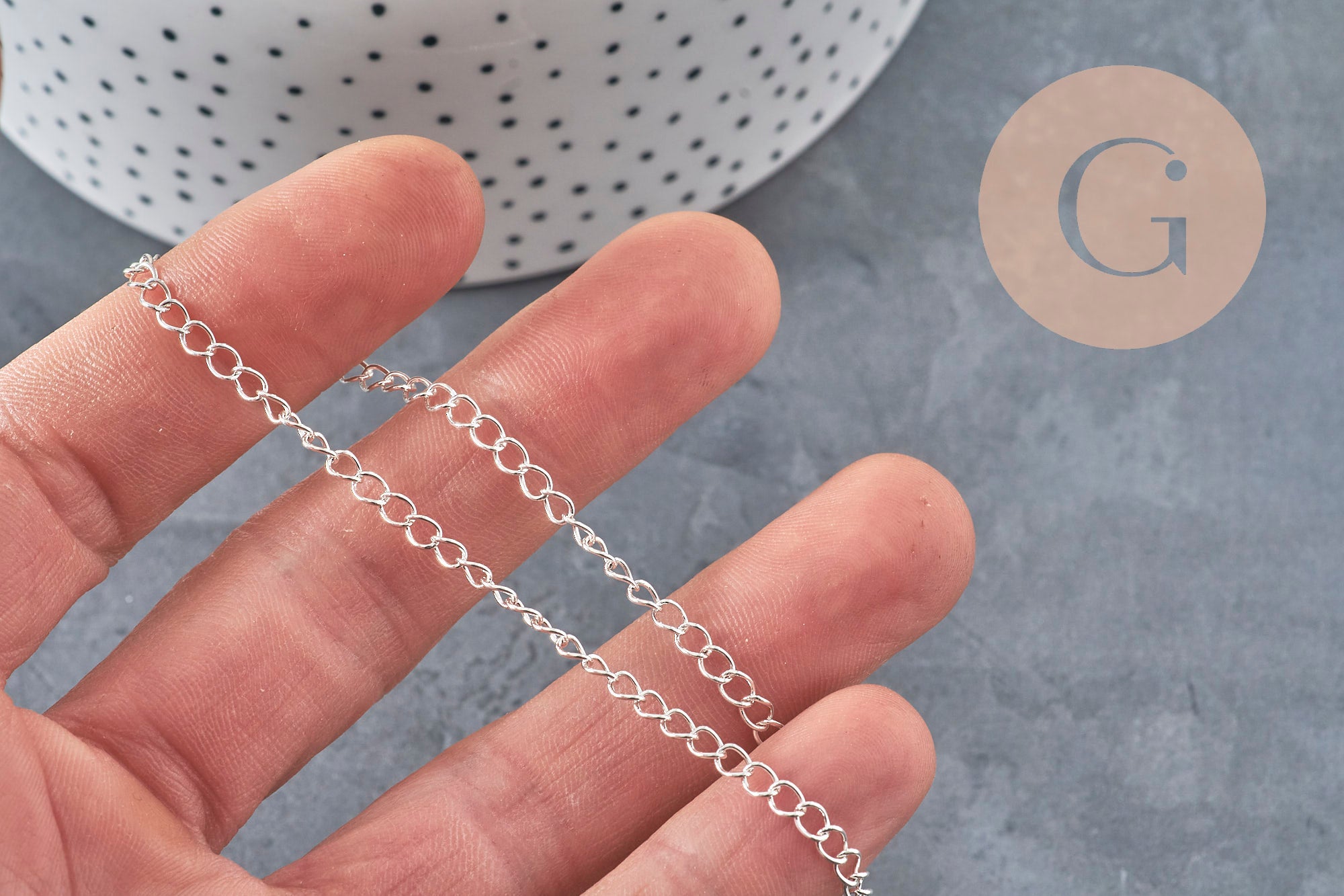 Chaîne maille courbe en acier inoxydable 304 argenté 4x3mm, tenue dans une main.
