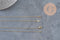 Collier chaîne fine dorée gold-filled 14K de 45.7cm avec fermoir, sur fond gris.