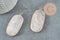Rose-quartz stone pendant framed in gold bezel on dark surface, showcasing the Pendentif hexagone quartz rose naturel 49mm (G2506), emphasizing its boho-chic style.
