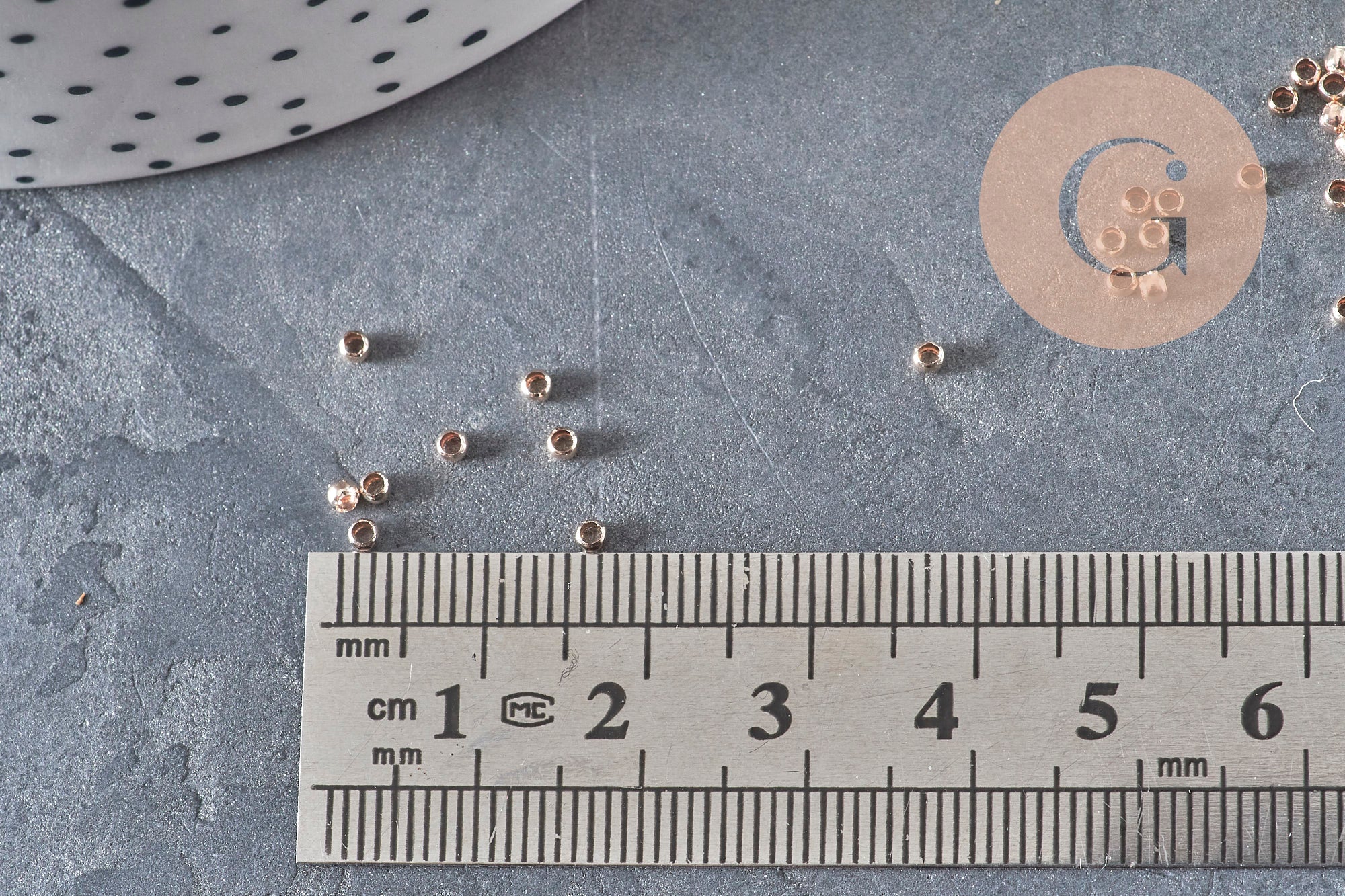 Petites perles à écraser en laiton or rose 2x1.2mm, avec règle de mesure.