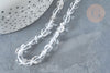 Translucent pebble-shaped glass beads, Perles cristal de roche roulée pierre brute, lie on a dark gray stone surface, beside a dotted white ceramic pot.
