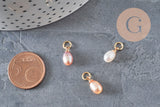 Trois breloques en perle d'eau douce naturelle forme goutte, teintes rose pêche et blanc, montées sur anneau en laiton doré.