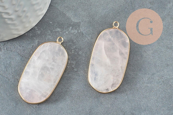 Rose-quartz stone pendant framed in gold bezel on dark surface, showcasing the Pendentif hexagone quartz rose naturel 49mm (G2506), emphasizing its boho-chic style.