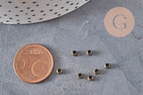 Perles à écraser rondelles en laiton couleur bronze 3x2mm, avec pièce de 5 centimes pour échelle.